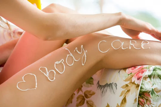 Woman with body care written on leg with lotion